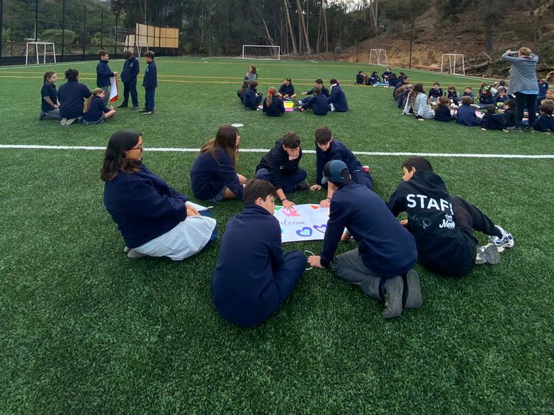Cursos trabajando sobre la cancha de pasto sintético del colegio