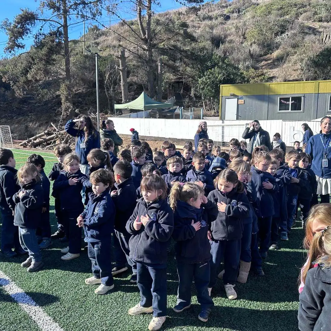 Estudiantes de todos los niveles reunidos en la cancha del colegio