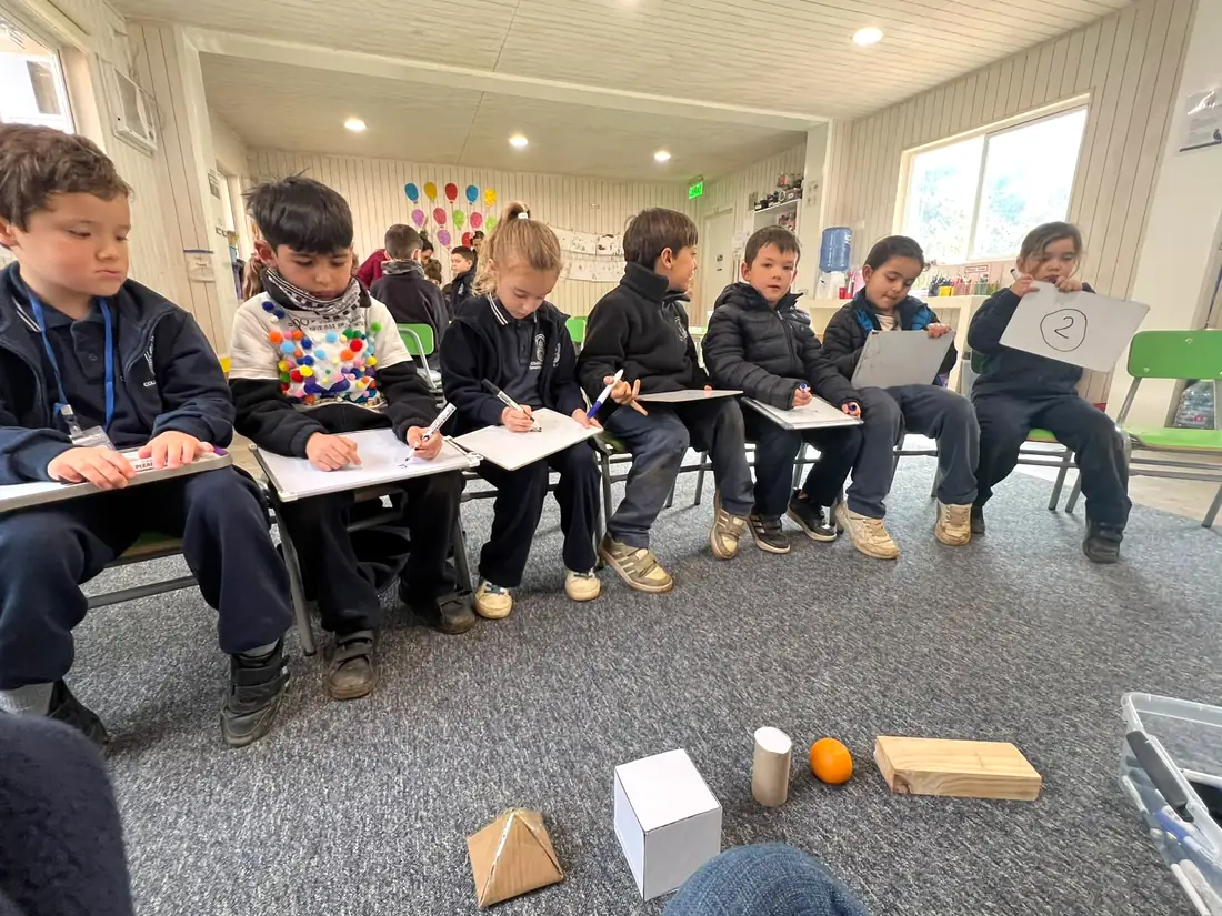 Estudiantes trabajando en una actividad educativa en la sala
